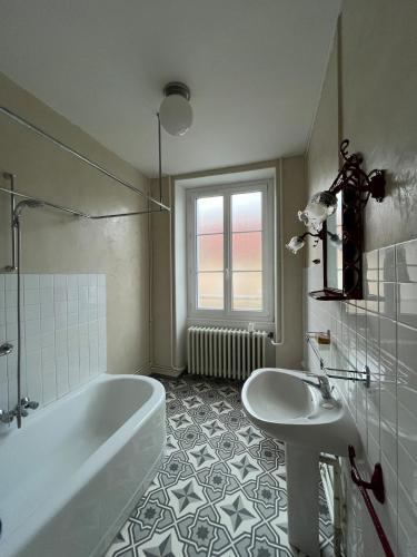 a bathroom with a tub and a sink at Gîte Chez Mamie Madeleine in Ainay-le-Château
