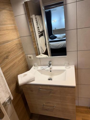 a bathroom with a sink and a mirror at Hotel La Basilique in Épinal