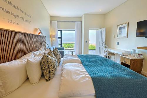 a bedroom with a large bed with a blue blanket at Oyster Box Guesthouse in Walvis Bay