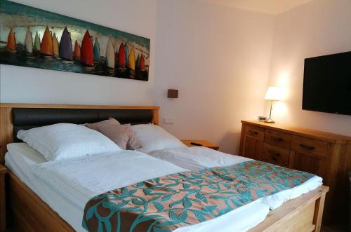 a bedroom with a bed and a flat screen tv at FEWO-Boddenblick-Vilm in Lauterbach