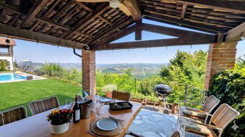 a patio with a table and chairs and a grill at Villa Perla, hilltop location with pool in Calosso