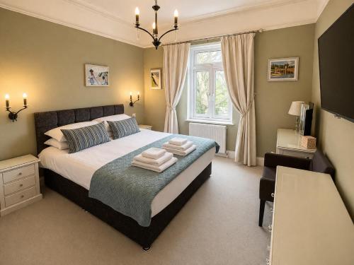 a bedroom with a bed with towels on it at Ferndale Lodge in Torquay