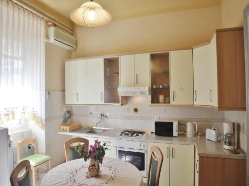 a kitchen with a table with a vase of flowers on it at Apartment Butković 312 in Pula