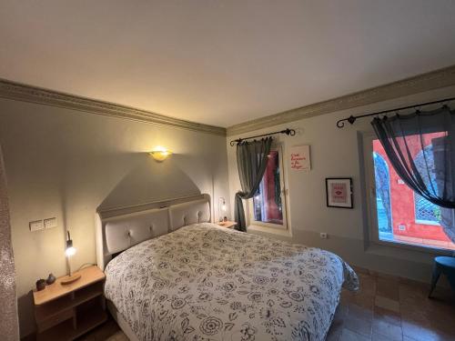 a bedroom with a bed and two windows at Escapade entre Mer et Montagnes in Saint-Martin-du-Var