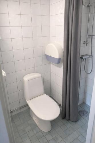 a white bathroom with a toilet and a shower at Apartment in central Båstad in Båstad