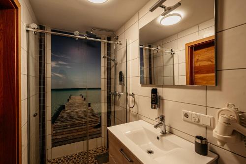a bathroom with a sink and a shower and a mirror at Hotel am Hafen Leverkusen in Leverkusen