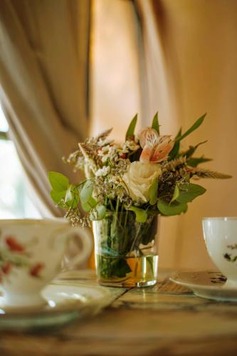 a vase filled with flowers sitting on a table at Don Aniceto Lodges & Glamping in Luján