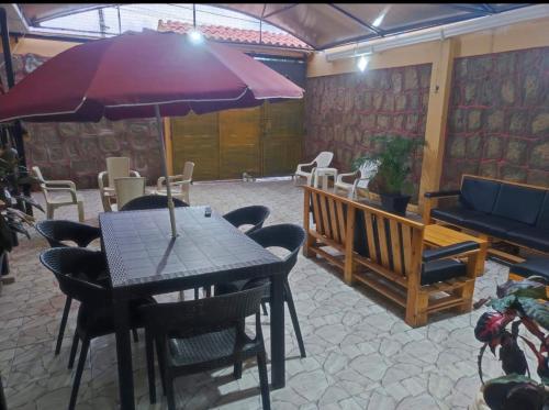 a patio with a table and chairs and an umbrella at Habitaciones de alquiler in La Libertad