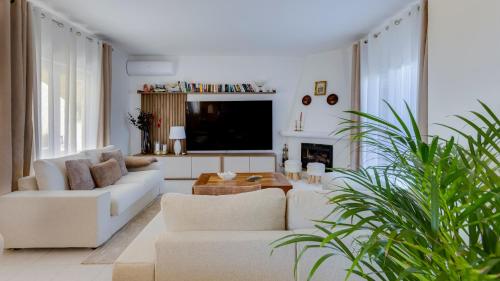 a living room with two white couches and a tv at Villa Arpeggio - Cozy 3-Bedroom Villa with Private Pool in Montinhos da Luz, Lagos in Mato Porcas