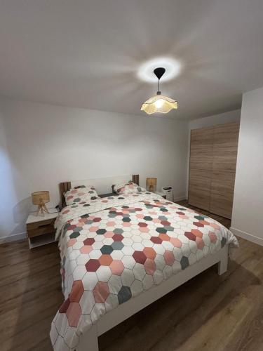 a bedroom with a bed with a colorful comforter at Panach in Saint-Loubès