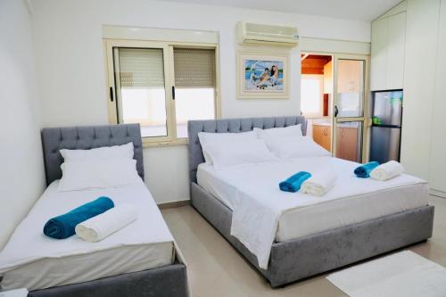 two beds in a bedroom with blue pillows on them at Gees House in Golem
