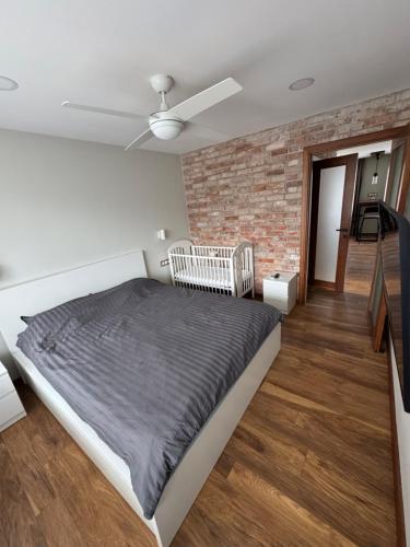 a bedroom with a bed and a brick wall at TK apartamenti 3 in Rēzekne