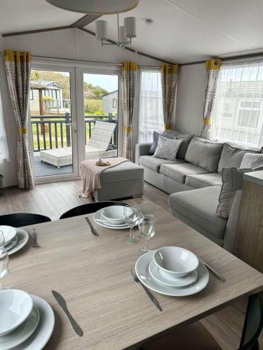 a living room with a table with plates and wine glasses at 820 Ocean View, Lydstep Haven Beach in Tenby