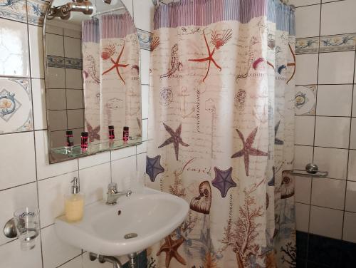 a bathroom with a sink and a shower curtain with stars at Avra Apartments in Leonidio