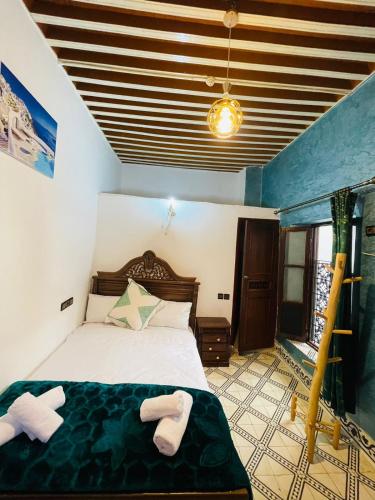 a bedroom with a bed with two towels on it at Dar Bab Boujloud Fez in Fez