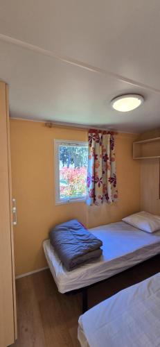 a small room with a bed and a window at Camping Fontisson in Châteauneuf-de-Gadagne