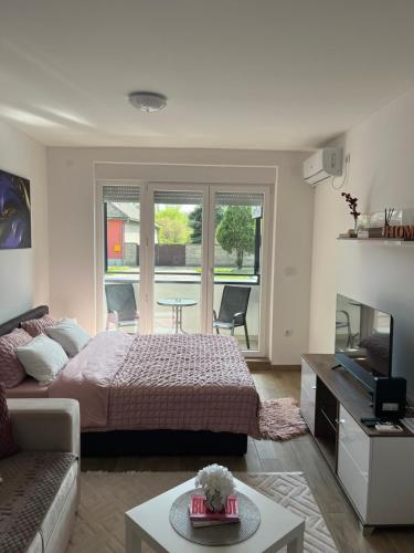 a bedroom with a bed and a living room at Studio Vila Alto in Vrbas
