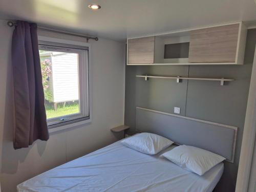 a small bedroom with a bed and a window at CAMPING RÊVE DES ILES in Argelès-sur-Mer