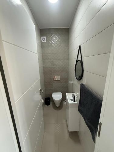 a small bathroom with a toilet and a sink at Miles Dreams Laginha in Mindelo