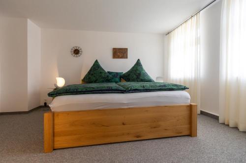 a bedroom with a bed with green pillows at Kerstins Lieblingsdomizil in Oelsnitz
