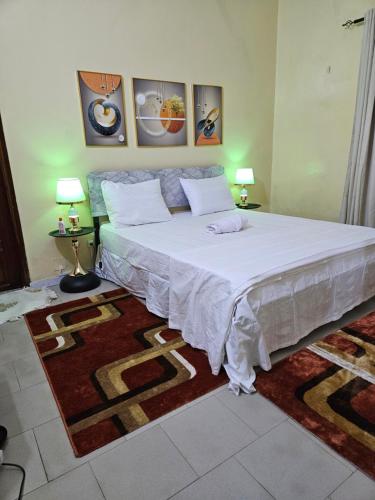 a bedroom with a large bed with a rug at Residence Ganou Mboro in Mboro
