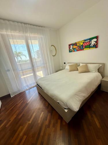 a bedroom with a large bed and a large window at Domus Leonardo Apartment in Fiumicino Airport