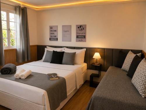 a hotel room with two beds and a couch at Casa da Marquês in Petrópolis