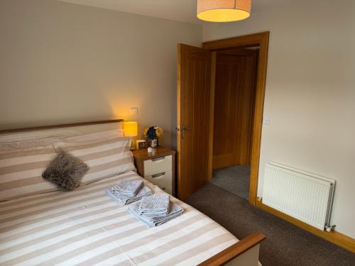 a bedroom with a bed with two towels on it at Marions Place in Finvoy