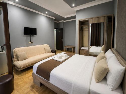 a bedroom with a large bed and a couch at Hotel Elite in Batumi