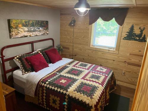 a bedroom with a bed with a quilt on it at Charming Rustic Barn in Spruce Pine