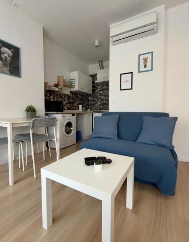 a living room with a blue couch and a table at Apartament z KLIMATYZACJĄ - ul Plebiscytowa 19 - darmowy parking in Opole