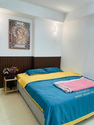a bedroom with a bed with blue and yellow sheets at The Timegarden Homestay in Ha Long