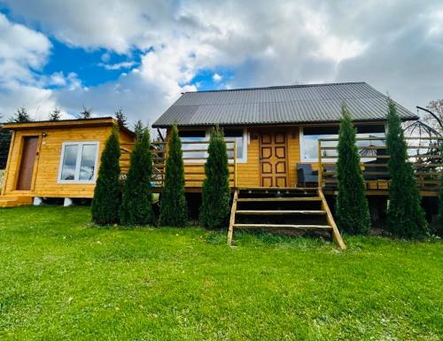 a wooden house with a bench in front of it at Dom BAnia Mazury SPA in Kukowo