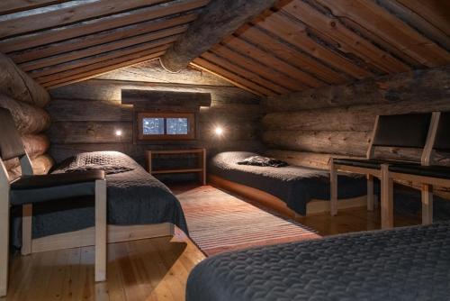 a bedroom with two beds in a log cabin at Villa Poronperä in Kuusamo