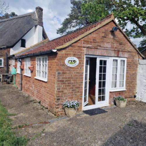 an old brick house with a window and a door at The Old Dairy, comfy 1 bedroom apartment with lounge,bathroom and kitchenette near town, pubs and walks in Ringwood