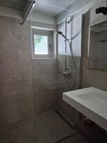 a bathroom with a shower and a sink at Port Griad in De Haan