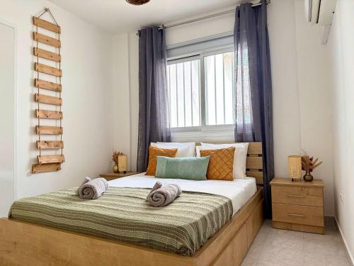 a bedroom with a large bed with a window at Coastal 2BR Apt in Mackenzie Steps from Beach by Cyprus Horizons in Scala