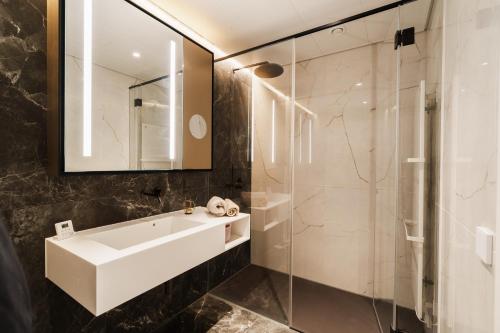 a bathroom with a sink and a glass shower at Above Danube - Luxury Apartment in Vienna