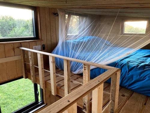a bed in a tiny house with a net at La tiny house Low Tech in Cléder