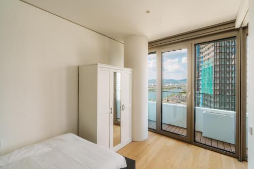 a bedroom with a bed and a large window at Above Danube - Luxury Apartment in Vienna