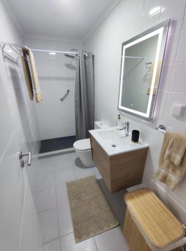 a bathroom with a sink and a toilet and a mirror at Refúgio Machiquense in Machico