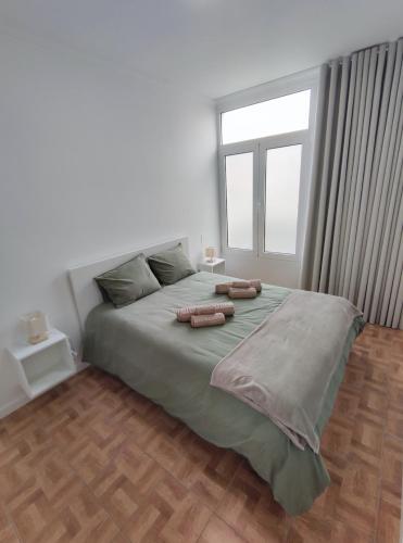a bedroom with a large bed with two pillows on it at Refúgio Machiquense in Machico