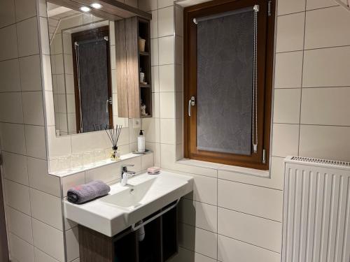 a white bathroom with a sink and a mirror at Chalet Z en Alsace in Barr