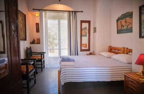a bedroom with two beds and a window at Trifillianika Traditional House in Trifilliánika