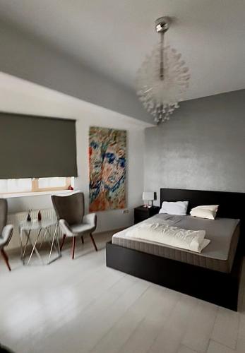 a bedroom with a large bed and a chandelier at Premier Apartaments by Twin Residence in Mamaia