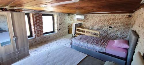 a bedroom with a bed and a brick wall at Begonvil Evleri Karaburun in Karaburun