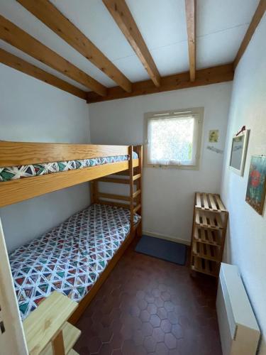 a room with two bunk beds and a window at Maison Maubuisson proche du lac de Carcans in Carcans
