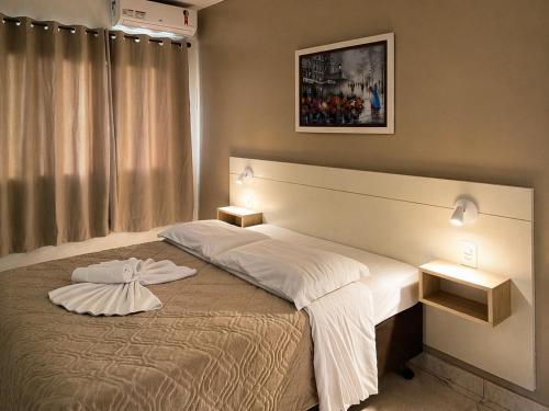 a bedroom with a large bed with two night stands at Pousada Bello Outono in Canela