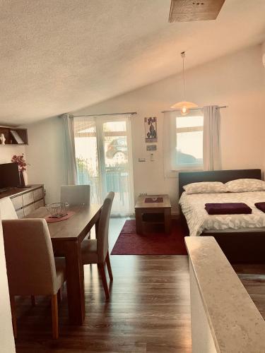 a bedroom with a bed and a table and a dining room at Apartments Dora in Poreč
