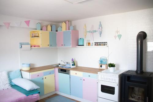 a kitchen with colorful cabinets and a stove at Buntes Bergglück 1923 in Ober-Gossen